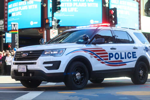 Police SUV with lights on in an urban environment