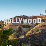 Hollywood Sign on a green hillside, sunny day.