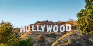 Hollywood Sign on a green hillside, sunny day.