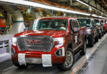 Red GMC pickup truck on an assembly line