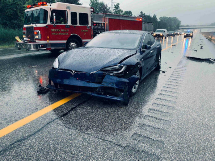 shutterstock_1478569319-1 Car crash with a Tesla on a rainy highway.