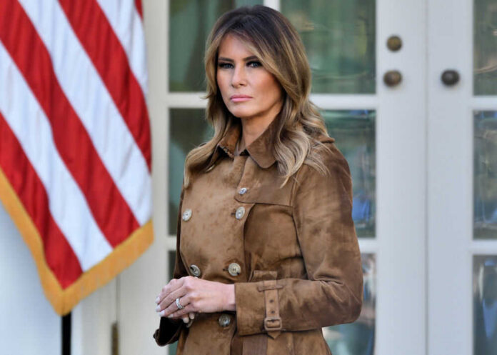 shutterstock_1572261598 Melania Trump standing outdoors in a brown suede trench coat