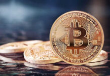 Bitcoin coins on a reflective surface.