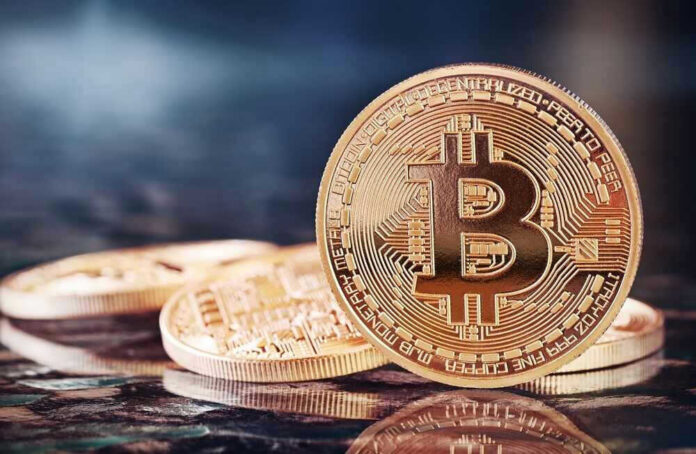 Bitcoin coins on a reflective surface.
