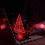 Terror Recruits Age 12 — Online! Warning symbol over laptop with user.
