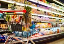 Listeria Alert Hits Walmart Shoppers Shopping cart filled with various groceries in a supermarket aisle