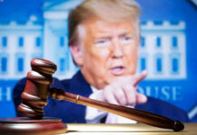Judge’s gavel with Donald Trump pointing in the blurred background