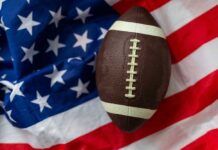 An American football resting on a background of the American flag