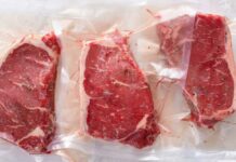 Three vacuum sealed steaks on a white surface