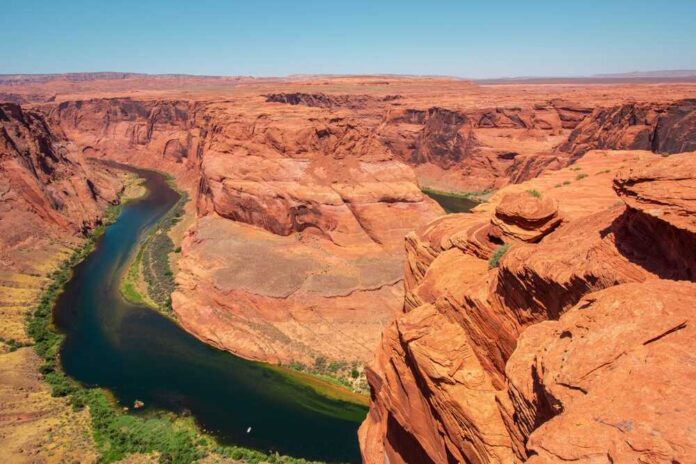 Colorado River winding through a red rock canyon under a clear blue sky
