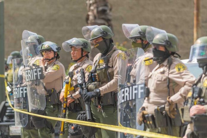 Dontrelle Inman and Danny White among sheriff deputies in riot gear holding shields