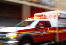 Ambulance with flashing lights speeding through a city street