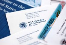 Trump Opens 17,500 Slots For One Refugee Group USCIS documents and a green card on a table
