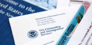 USCIS documents and a green card on a table