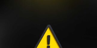 Yellow triangular warning sign with exclamation mark on black background