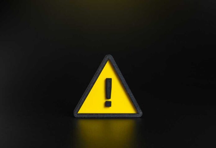 Yellow triangular warning sign with exclamation mark on black background