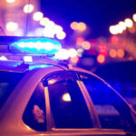 Police car with blue lights flashing at night.