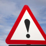 Flight Vanishes — Coast Guard Scrambles Warning road sign with exclamation mark against a cloudy sky