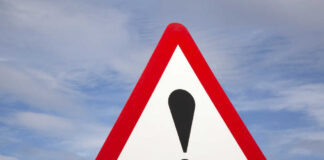 Flight Vanishes — Coast Guard Scrambles Warning road sign with exclamation mark against a cloudy sky