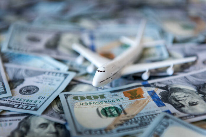 White,Plane,On,Dollar,Cash,Closeup Toy airplane on scattered US dollar bills