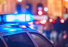 Close-up of a police car with blue emergency lights in a city at night
