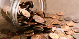Penny Axed – Nickel Next? Bundles of cash next to a stethoscope and a note that says 'COST OF CARE'