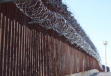 Border fence topped with coils of razor wire