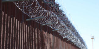 Border fence topped with coils of razor wire