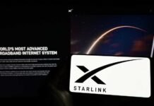 A smartphone displaying the Starlink logo in front of a screen showing a space image