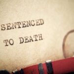 Execution Plan Suddenly Wobbles Close-up of a typewritten document stating 'SENTENCED TO DEATH'
