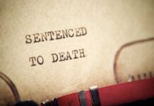 Execution Plan Suddenly Wobbles Close-up of a typewritten document stating 'SENTENCED TO DEATH'