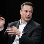 Musk Targets Lawmakers Elon Musk in a suit talking.