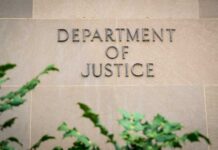 Sign displaying 'Department of Justice' on a stone wall