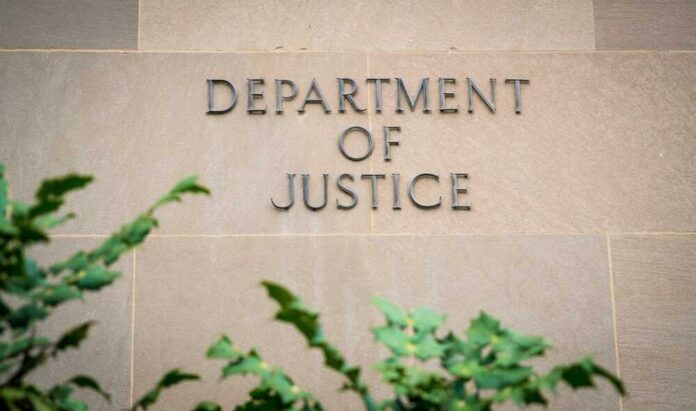 The,United,States,Department,Of,Justice,(doj),In,Washington,D.c., Sign displaying 'Department of Justice' on a stone wall