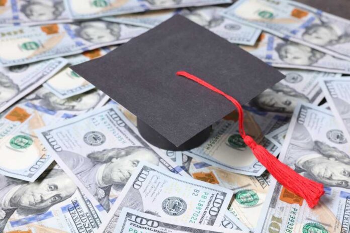 Graduation cap with red tassel on scattered US dollar bills