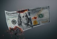 Burning US hundred-dollar bill with embers and holes