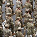 Timmy Jernigan among soldiers marching in formation on a street