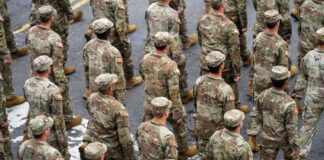 Timmy Jernigan among soldiers marching in formation on a street