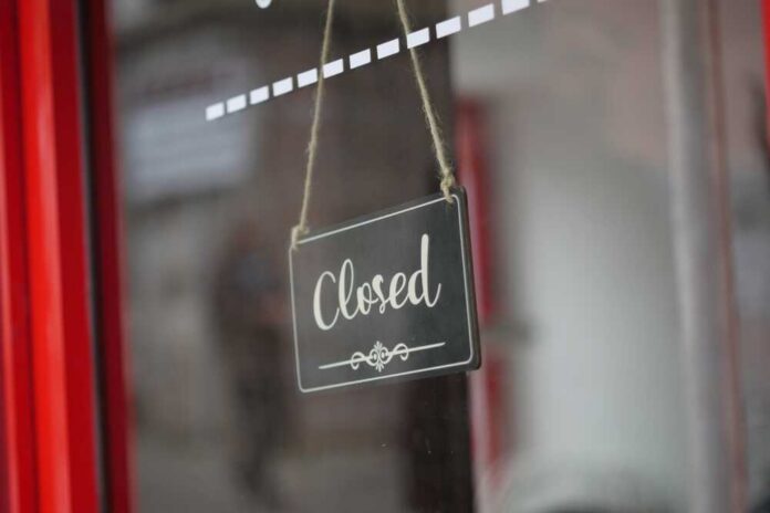A closed sign hanging on a shop window