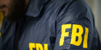 FBI Ambush Stuns Beijing FBI agent in navy blue jacket.