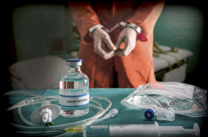 Handcuffed person behind Sodium Thiopental and medical equipment.